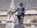 Hamo Thornycroft (1850 - 1925), Statue of Oliver Cromwell outside the Palace of Westminster, 1829, Farbfotografie von 2009, Fotograf: Elliott Brown. Bildquelle: Wikimedia Commons, https://en.wikipedia.org/wiki/File:Statue_of_Oliver_Cromwell_outside_the_Palace_of_Westminster.jpg, gemeinfrei.