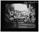 League of Nations Malaria Investigation Committee, United Provinces, India: Anti-malaria educational play put on by youngsters dealing with the treatment of the disease, the use of quinine, Schwarz-Weiß-Negativ, ca. 1929–1930, unbekannter Photograph; Bildquelle:  Library of Congress Prints and Photographs Division, LC-USW33-043118-ZC, http://hdl.loc.gov/loc.pnp/fsa.8e02362, gemeinfrei.